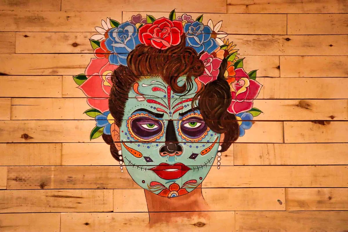Day of the Dead mural painted on the wood plank wall