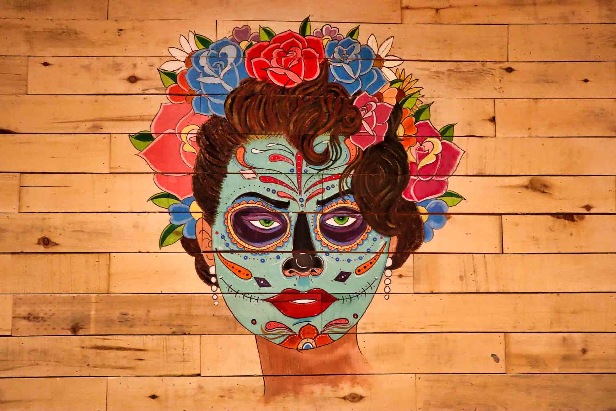 Day of the Dead mural painted on the wood plank wall